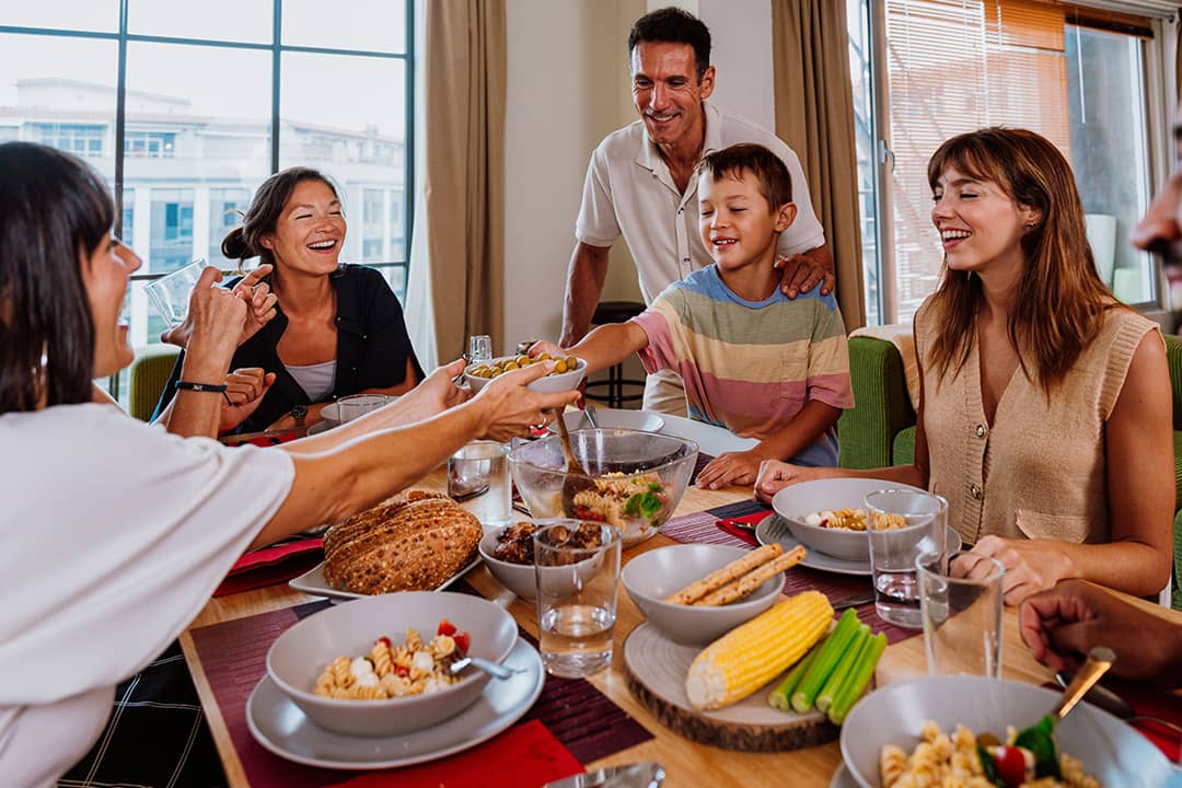 A diverse, multigenerational family sharing meals at the dinner table.
